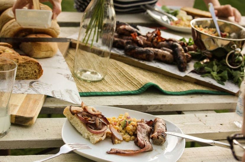 An outdoor spread of grilled food and drinks